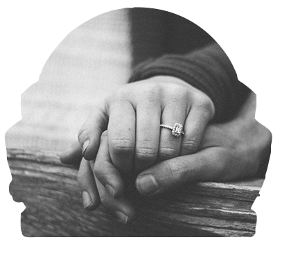 couple holding hands with an engagement ring on her finger
